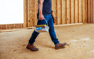 a man walking on the construction site with power pro wood screws keg