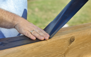 a man laying down joist tape onto a beam